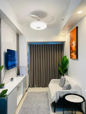 a living room with a couch and a television at Shore 3 Residences in Manila
