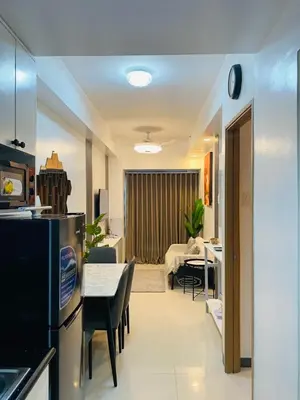 a kitchen and living room with a table and a refrigerator at Shore 3 Residences in Manila