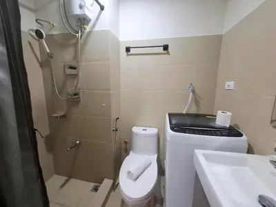 a bathroom with a shower and a toilet and a sink at Shore 3 Residences in Manila
