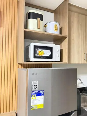 a microwave sitting on top of a refrigerator in a kitchen at NEW One Bedroom Condo Unit in Manila