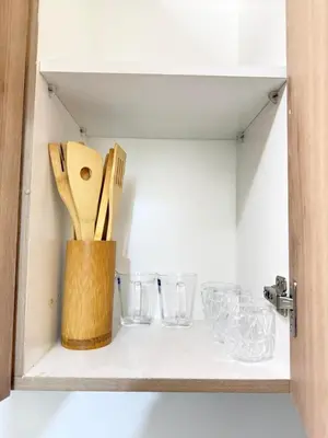 a cupboard with wooden utensils and glasses on it at NEW One Bedroom Condo Unit in Manila