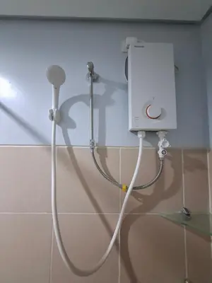 a shower with a white hose attached to a wall at Cozy Hotel-Style Studio Unit for Rent at Eastbay Residences by Rockwell in Manila