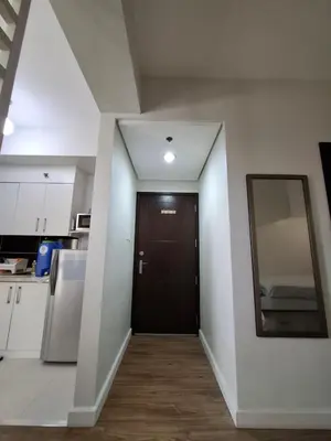 a hallway with a black door in a kitchen at Cozy Hotel-Style Studio Unit for Rent at Eastbay Residences by Rockwell in Manila