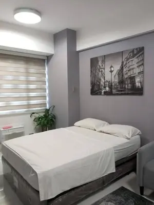 a bedroom with a large bed and a window at Sea Residences in Manila