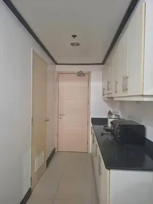 a kitchen with a black counter and a door at Sea Residences in Manila