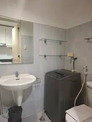 a bathroom with a sink and a toilet and a mirror at Sea Residences in Manila