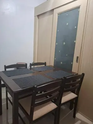 a wooden table with two chairs and a window at Sea Residences in Manila