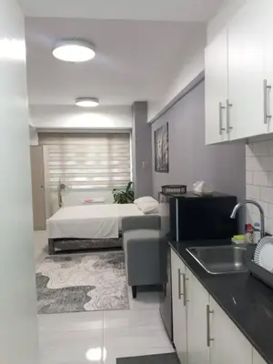 a kitchen with a bedroom with a bed and a sink at Sea Residences in Manila