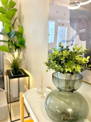 a vase with flowers in it on a table at Uptown Parksuites - Elegant 2 Bedroom Unit with Balcony in BGC in Manila