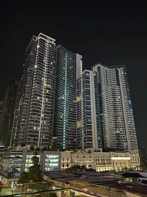 a group of tall buildings in a city at night at Uptown Parksuites - Elegant 2 Bedroom Unit with Balcony in BGC in Manila