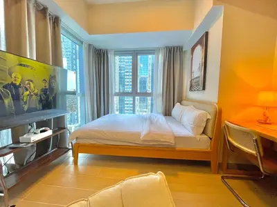a bedroom with a bed and a large window at Uptown Parksuites - Elegant 2 Bedroom Unit with Balcony in BGC in Manila
