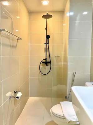 a bathroom with a shower with a toilet and a sink at Uptown Parksuites - Elegant 2 Bedroom Unit with Balcony in BGC in Manila