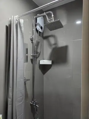 a shower in a bathroom with a shower curtain at Air Residences in Manila