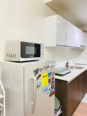 a microwave on top of a refrigerator in a kitchen at Air Residences in Manila
