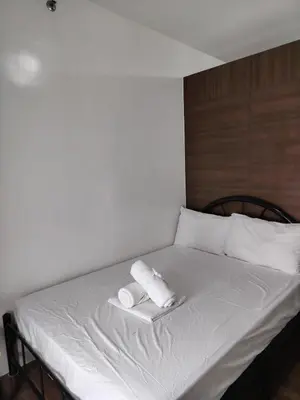 a bed with two rolled towels on top of it at Air Residences in Manila