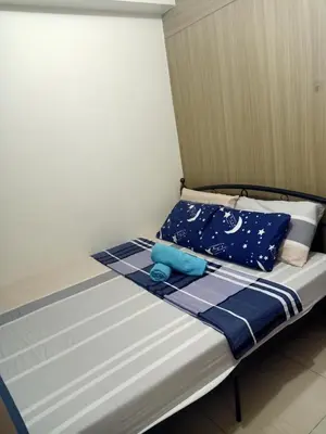 a bed with a blue teddy bear sitting on it at Staycation in Shore Residence's in Manila