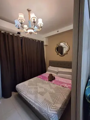 a bedroom with a bed and a chandelier at 3sonstaycation in Manila