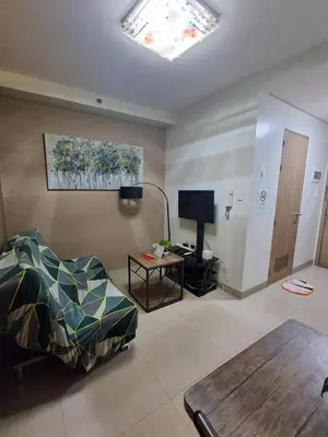 a living room with a bed and a table at 3sonstaycation in Manila