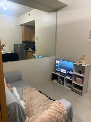 a living room with a couch and a television at Sun&sky city escape in Manila