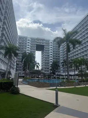 a large building with palm trees in front of it at Sun&sky city escape in Manila