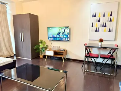 a living room with a glass table and a tv at Makati City Poblacion 1 bedroom with balcony in Manila