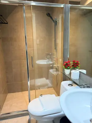 a bathroom with a shower and a toilet and a sink at Makati City Poblacion 1 bedroom with balcony in Manila