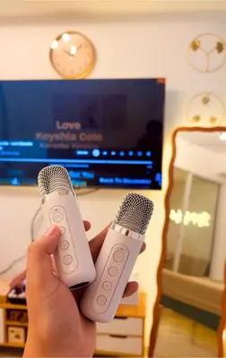 a person holding two microphones in front of a tv at 1BR 4Pax Condo Azure Beach Resort Pool View Fully Furnished with PS4 in Manila
