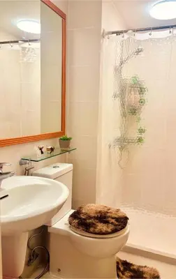 a bathroom with a toilet and a sink and a shower at 1BR 4Pax Condo Azure Beach Resort Pool View Fully Furnished with PS4 in Manila