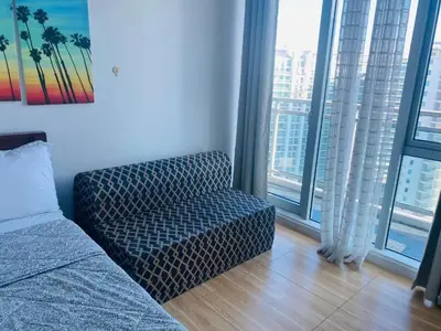 a living room with a couch and large windows at Azure Urban Resort Residence Wavepool A52 in Manila