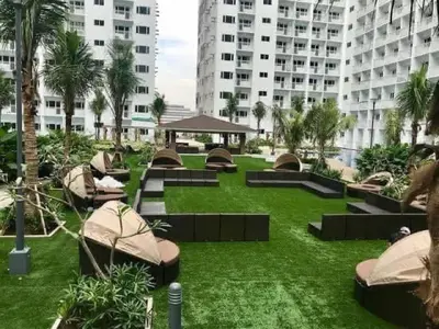 a park with benches and palm trees and buildings at Shore residence A42 shortwalk mall of asia in Manila
