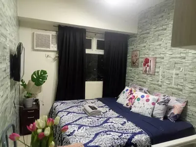 a bedroom with a bed with a phone on it at Urban Deca Tower at Mandaluyong in Manila