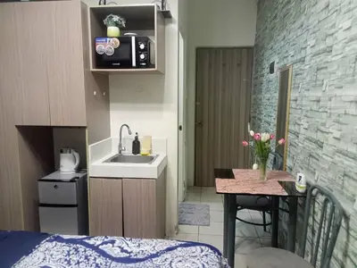 a small kitchen with a sink and a table at Urban Deca Tower at Mandaluyong in Manila