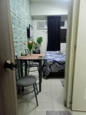 a small room with a table and a bed at Urban Deca Tower at Mandaluyong in Manila