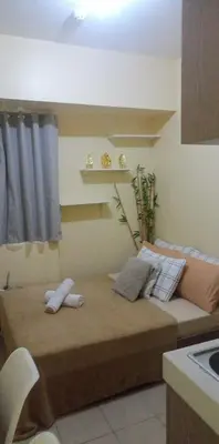 a room with a bed with a shelf on the wall at Urban Deca Tower at Mandaluyong in Manila