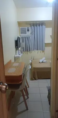 a room with a desk and a bed and a window at Urban Deca Tower at Mandaluyong in Manila