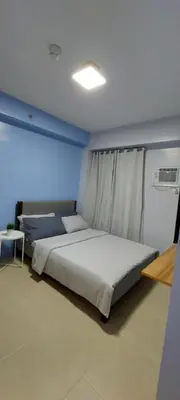 a bedroom with two beds and a blue wall at Avida Sucat Paranaque City in Manila