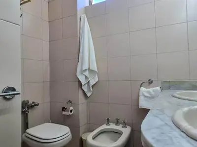 a white bathroom with a toilet and a sink at Pure Stay Apartments in Manila