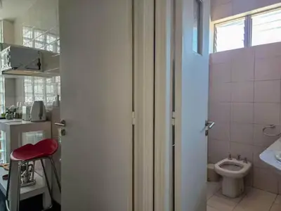 a bathroom with a toilet and a red stool at Pure Stay Apartments in Manila