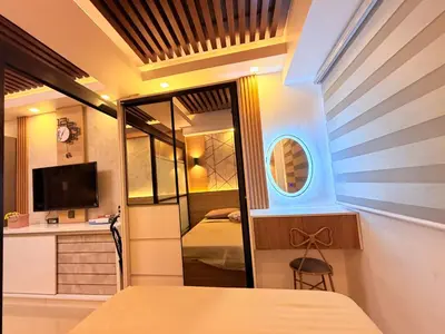 a room with a bed and a tv and a mirror at Bayshore Getaway Condotel ByClowie in Manila