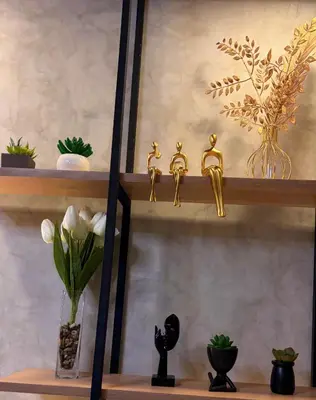a shelf with gold items and a vase with flowers at Bayshore Getaway Condotel ByClowie in Manila