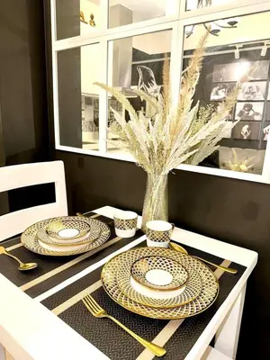 a dining room table with plates and utensils on it at Dream Catchers Azure Staycation in Manila