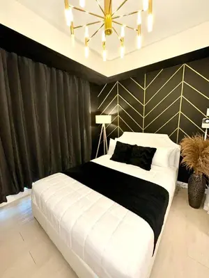 a bedroom with a large white bed and a chandelier at Dream Catchers Azure Staycation in Manila