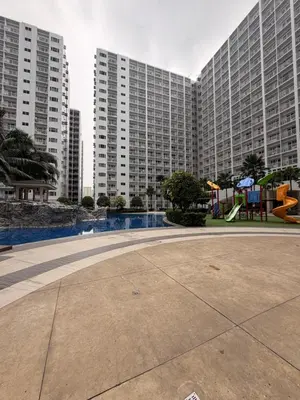 a large apartment building with a playground in front of it at Direct Access to pool GK Suite in Manila