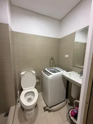 a small bathroom with a toilet and a sink at Luxe Condo at MOA in Manila