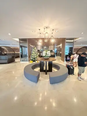 a lobby with a circular table in the middle of a building at Luxe Condo at MOA in Manila