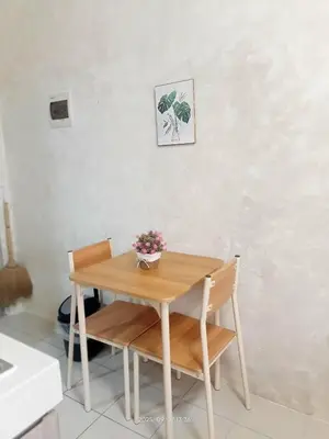 a wooden table and two chairs with a plant on it at Urban Deca Tower at Mandaluyong in Manila