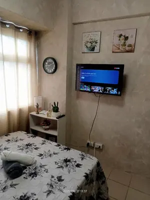 a bedroom with a bed and a tv on the wall at Urban Deca Tower at Mandaluyong in Manila