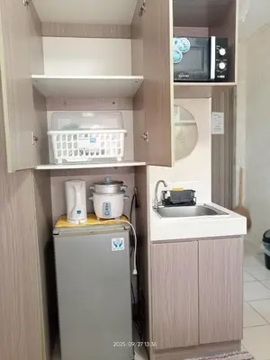 a small kitchen with a refrigerator and a sink at Urban Deca Tower at Mandaluyong in Manila