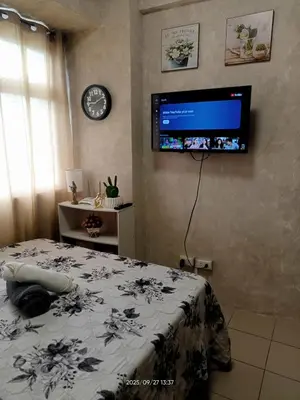 a bedroom with a bed and a tv on the wall at Urban Deca Tower at Mandaluyong in Manila
