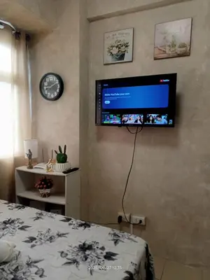 a bedroom with a flat screen tv on the wall at Urban Deca Tower at Mandaluyong in Manila